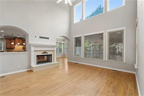 wooden floor fireplace and windows in an empty room