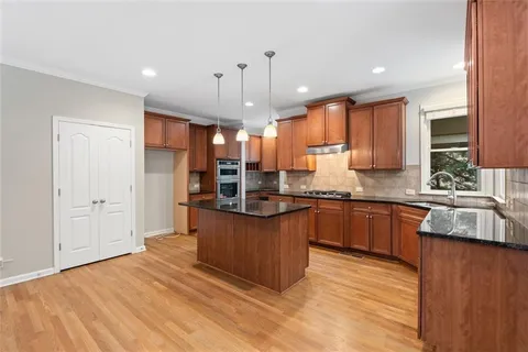 a kitchen with stainless steel appliances granite countertop a sink refrigerator and cabinets