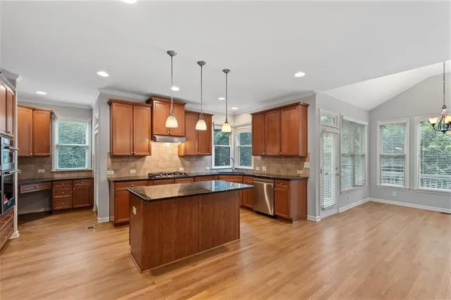 a kitchen with stainless steel appliances granite countertop wooden floors and sink