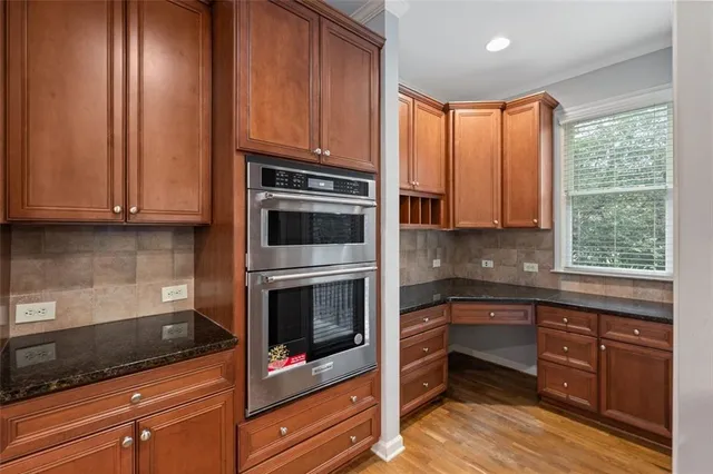a kitchen with stainless steel appliances granite countertop wooden cabinets and a stove top oven