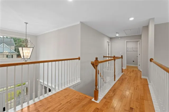 a view of a hallway with wooden floor and stairs