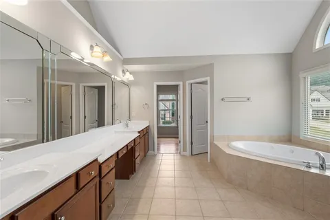 a spacious bathroom with a granite countertop tub sink and mirror