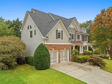 a view of a white house next to a yard
