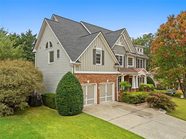 a view of a white house next to a yard