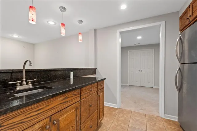 a kitchen with stainless steel appliances granite countertop a sink and a refrigerator