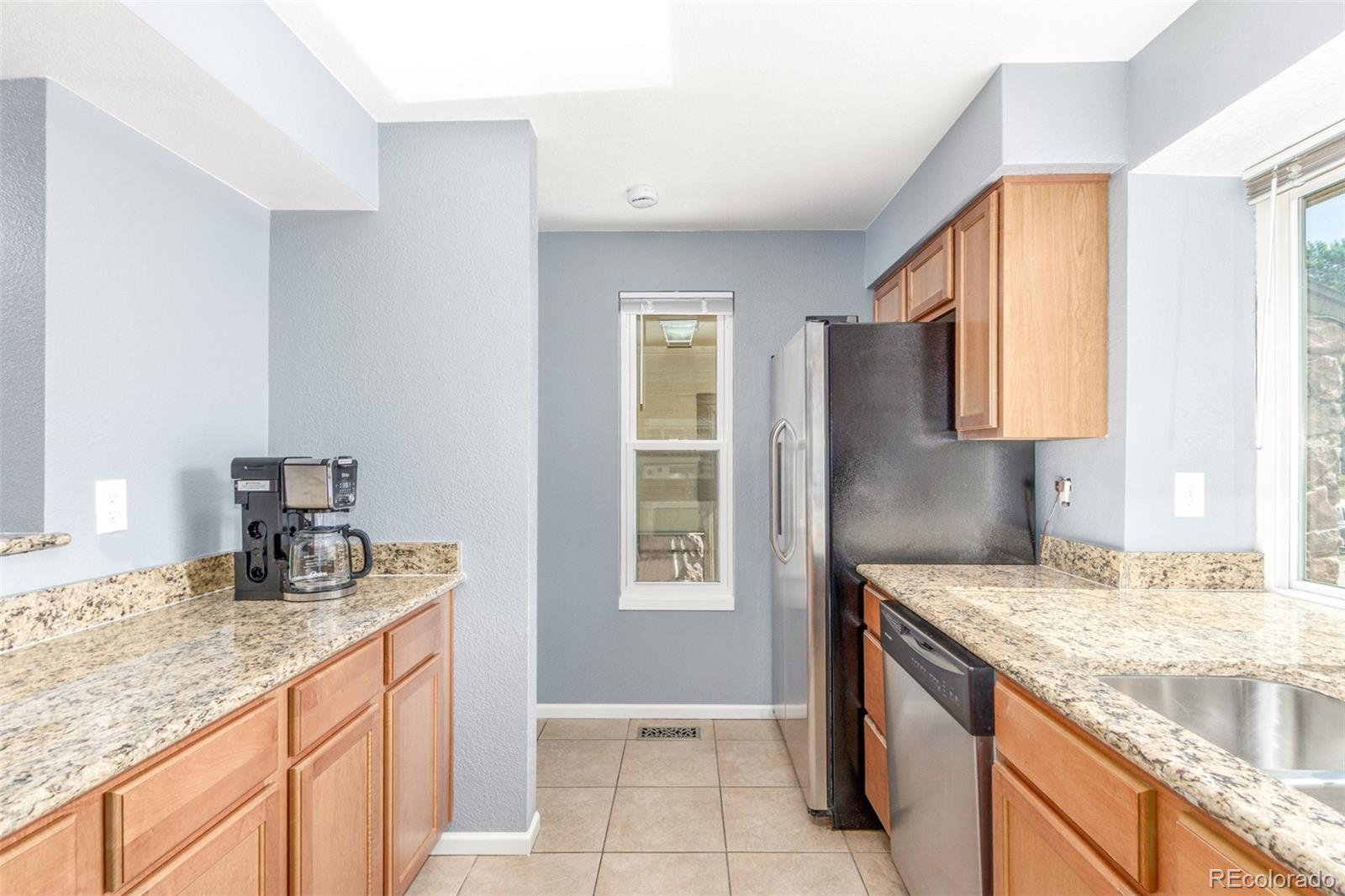 5105 Chandler Way Denver, CO 80239 - Photo 12 of 32 a kitchen with granite countertop a sink and a stove