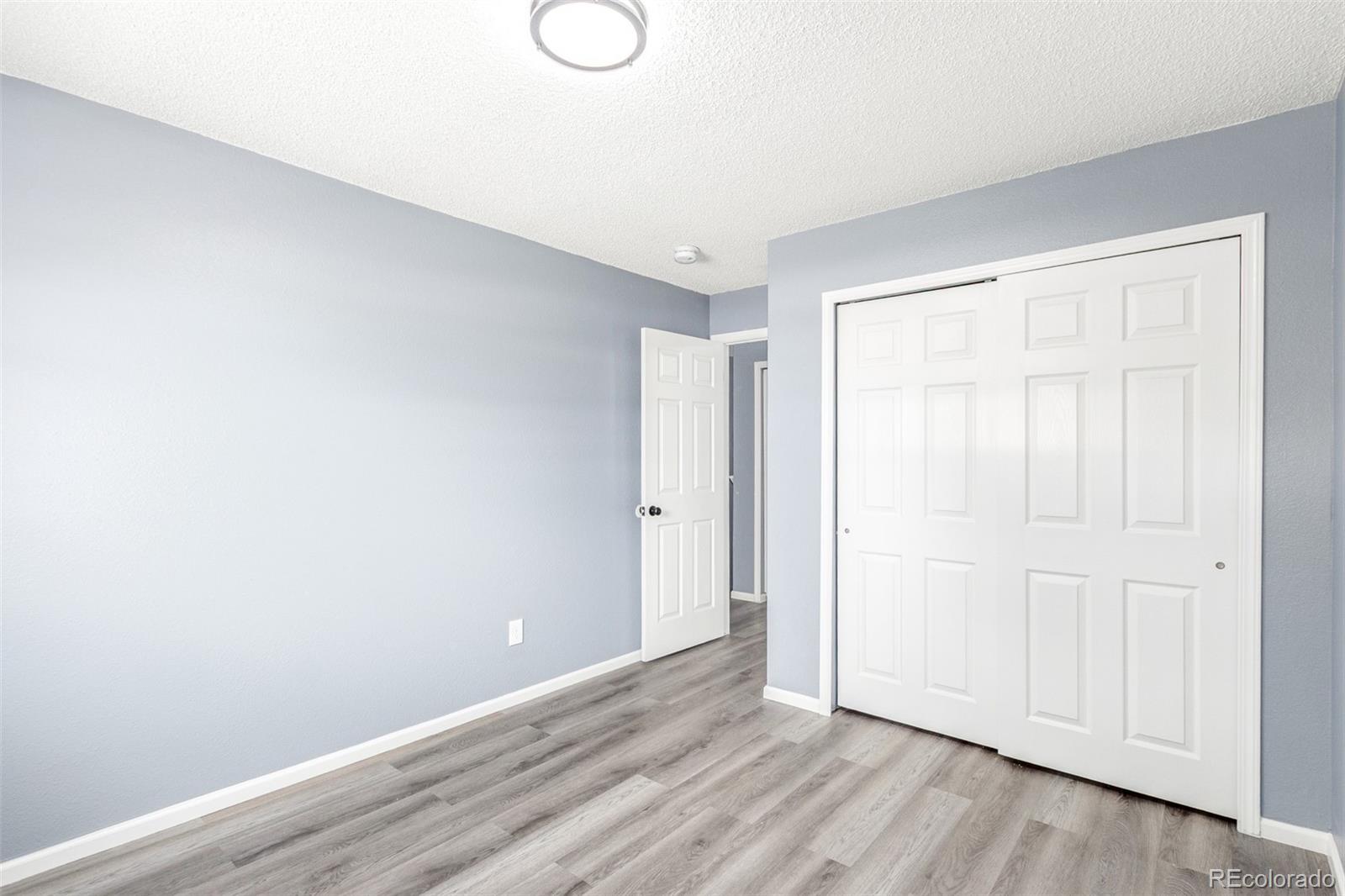 5105 Chandler Way Denver, CO 80239 - Photo 22 of 32 a view of an empty room and wooden floor