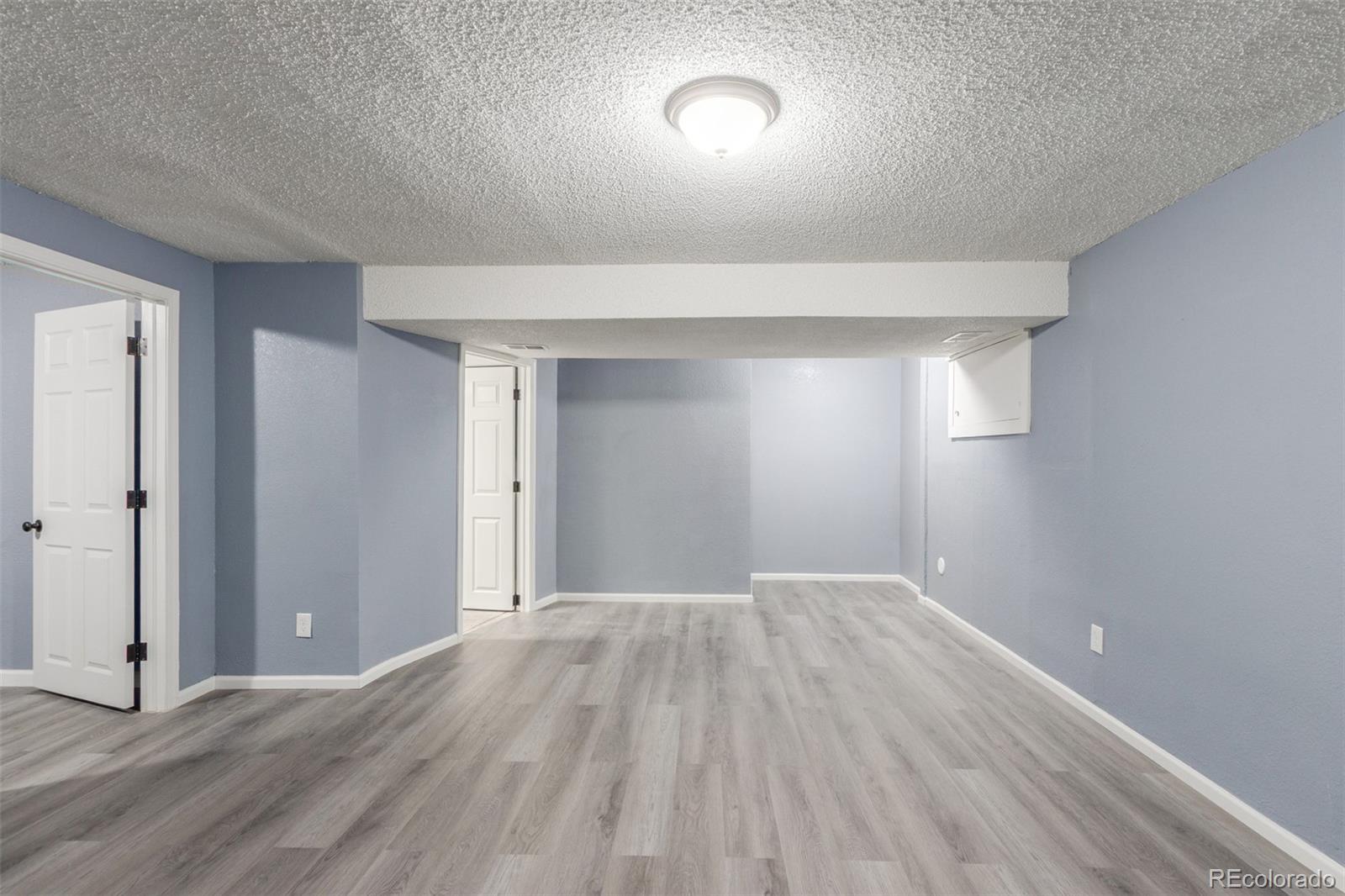 5105 Chandler Way Denver, CO 80239 - Photo 24 of 32 an empty room with wooden floor and windows