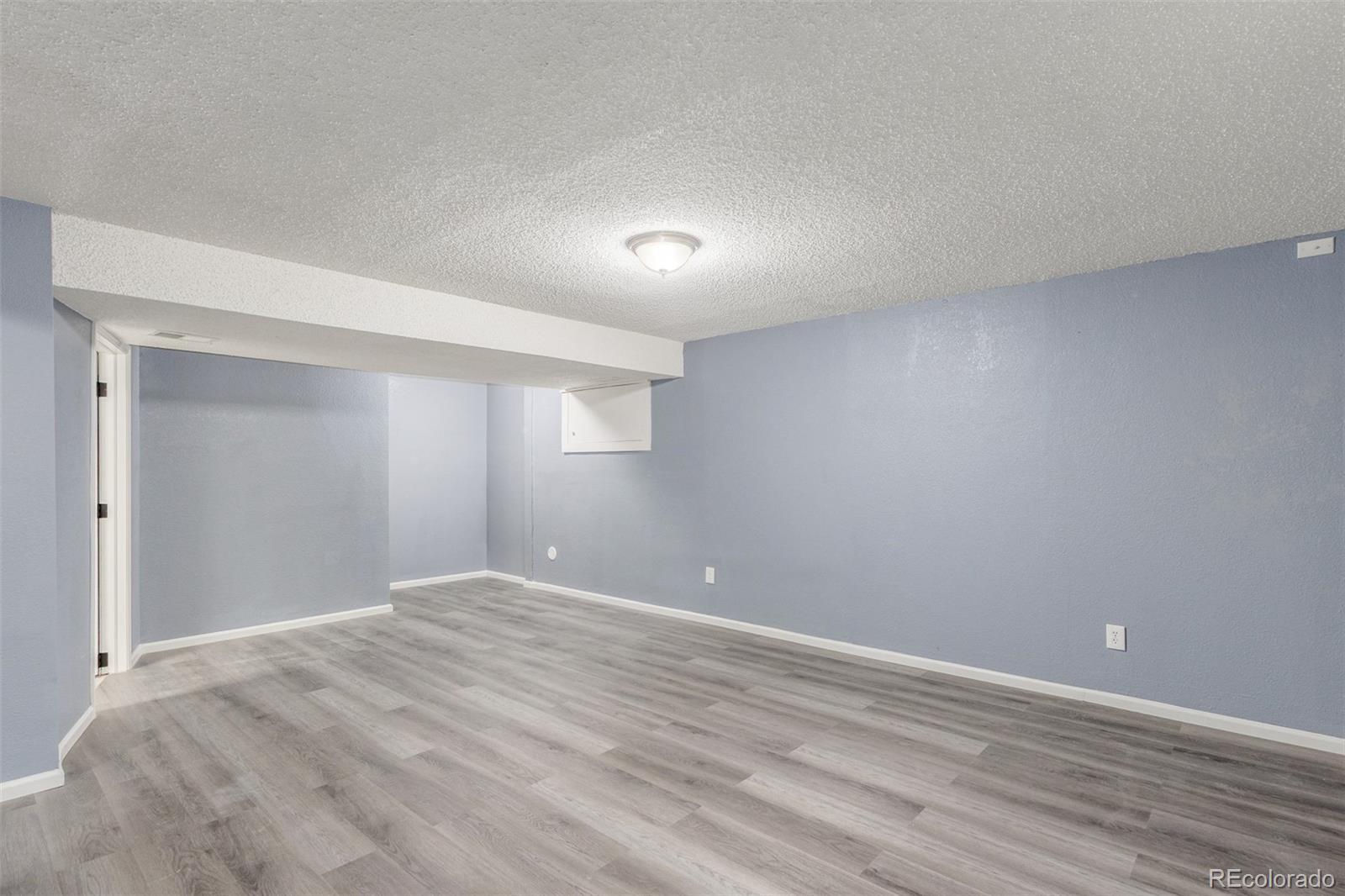 5105 Chandler Way Denver, CO 80239 - Photo 25 of 32 a view of an empty room with wooden floor