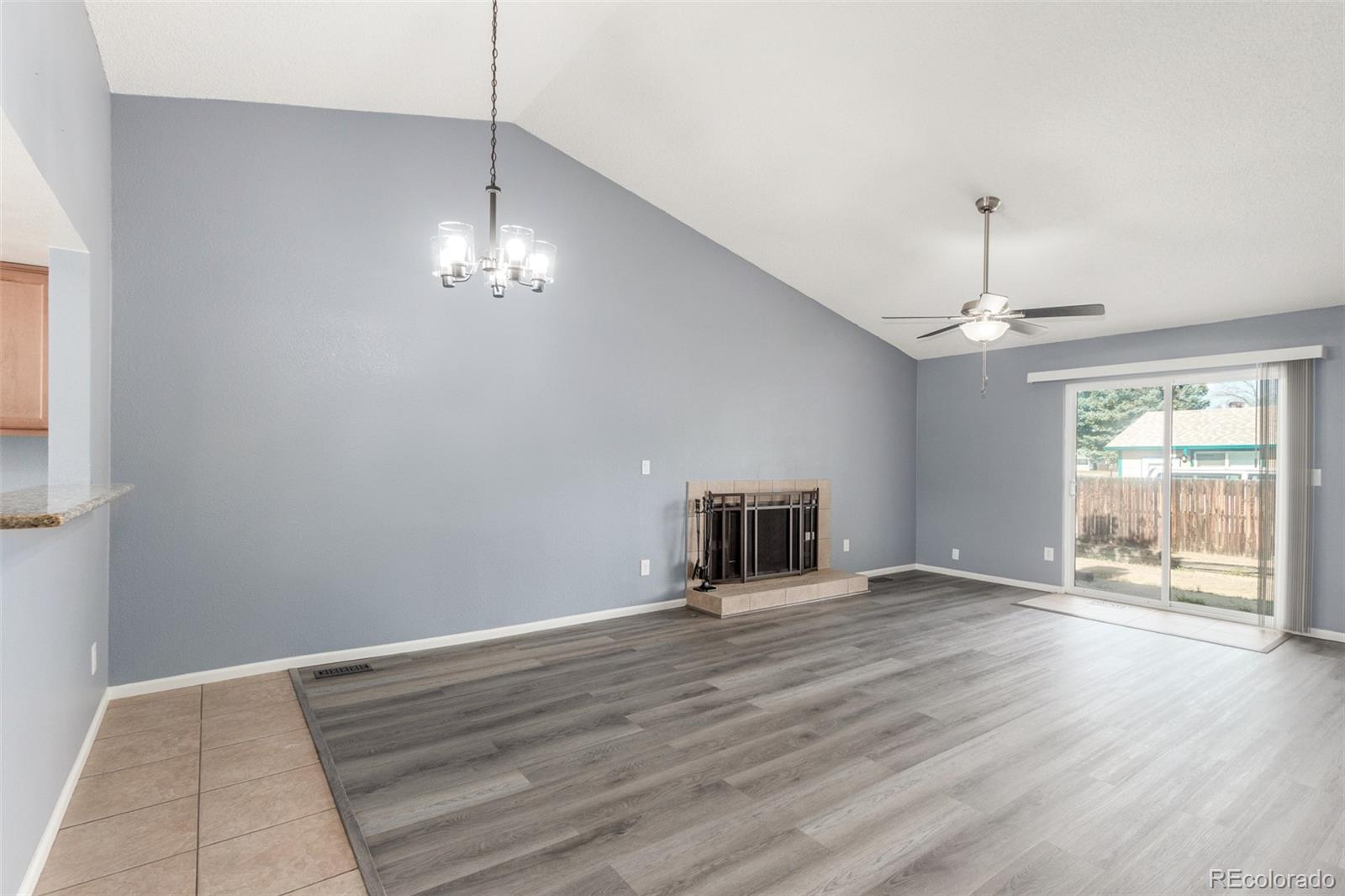 5105 Chandler Way Denver, CO 80239 - Photo 5 of 32 a view of a livingroom with wooden floor a ceiling fan and window