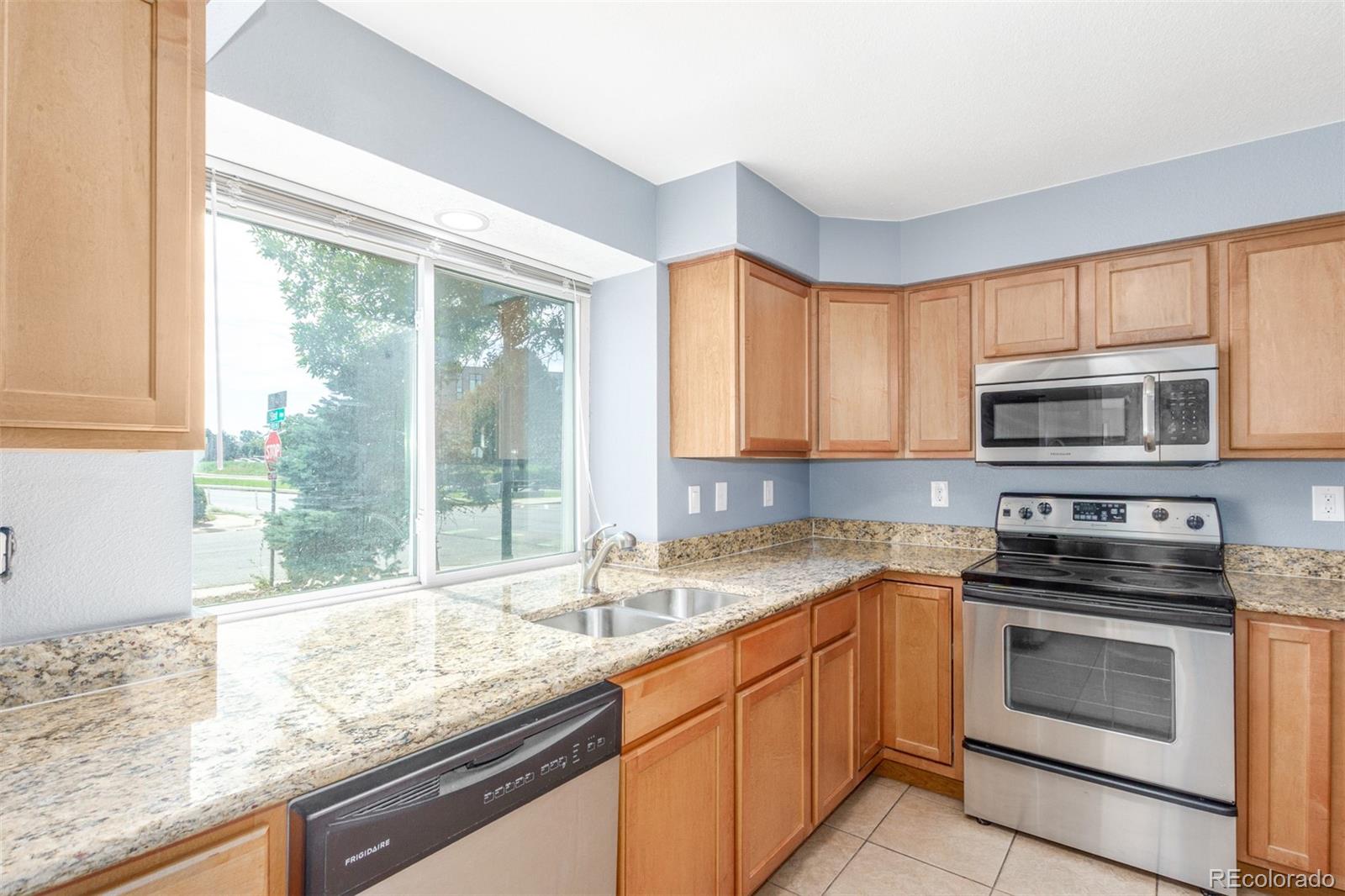 5105 Chandler Way Denver, CO 80239 - Photo 10 of 32 a kitchen with granite countertop a sink appliances cabinets and a counter top space