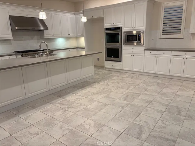 a kitchen with stainless steel appliances granite countertop a sink and a stove