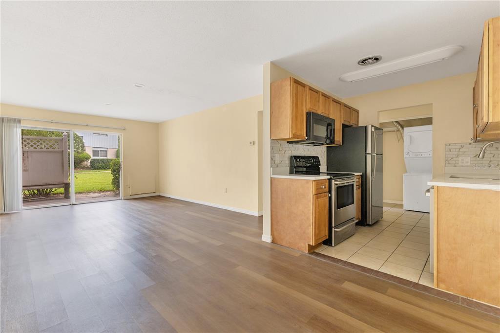 1695 Lee Road, Unit E103 Winter Park, FL 32789 - Photo 14 of 20 a kitchen with stainless steel appliances a stove a refrigerator a sink a oven with wooden floor and cabinets
