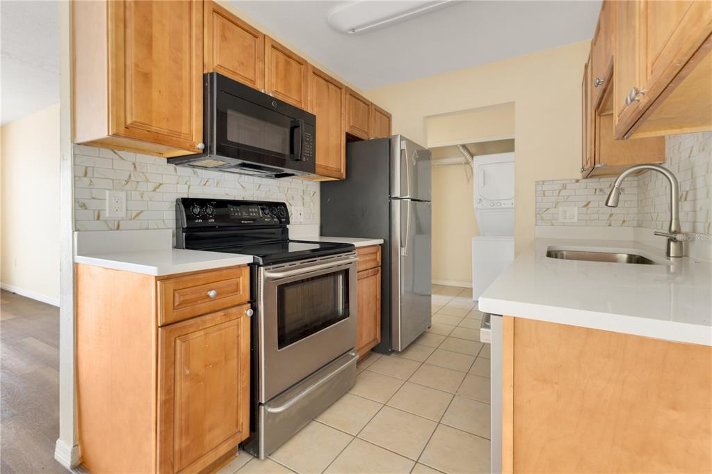 1695 Lee Road, Unit E103 Winter Park, FL 32789 - Photo 17 of 20 a kitchen with stainless steel appliances a stove a sink a microwave and cabinets