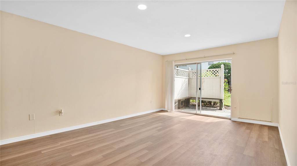 1695 Lee Road, Unit E103 Winter Park, FL 32789 - Photo 4 of 20 an empty room with a fireplace and wooden floor