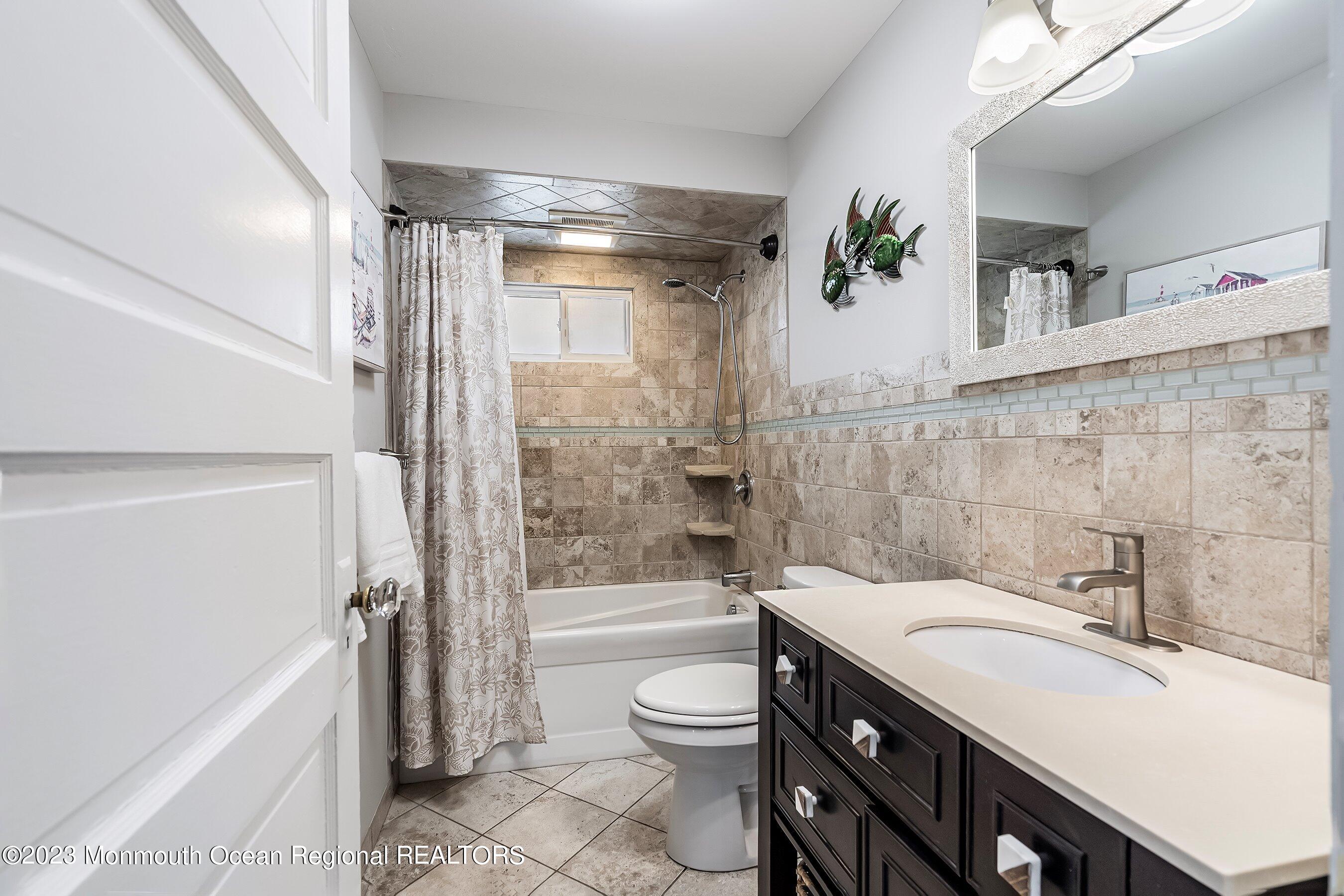1401 B Street, Unit DOWNSTAIRS Belmar, NJ 07719 - Photo 7 of 12 a bathroom with a granite countertop sink toilet a mirror and shower