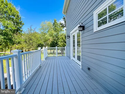 an empty room with wooden floor fireplace and windows