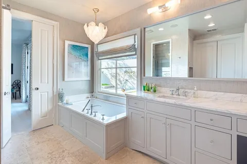 a bathroom with a granite countertop sink and a bathtub