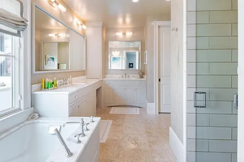 a bathroom with a tub sink and mirror