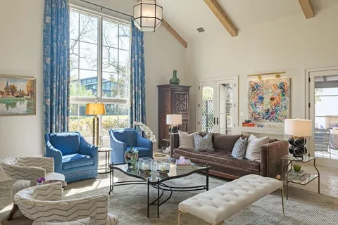 a living room with furniture wooden floor and a large window