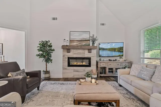 a living room with furniture a flat screen tv and a fireplace