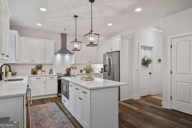 a kitchen with a sink a refrigerator and a stove top oven