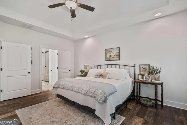 a spacious bedroom with a bed and a chandelier