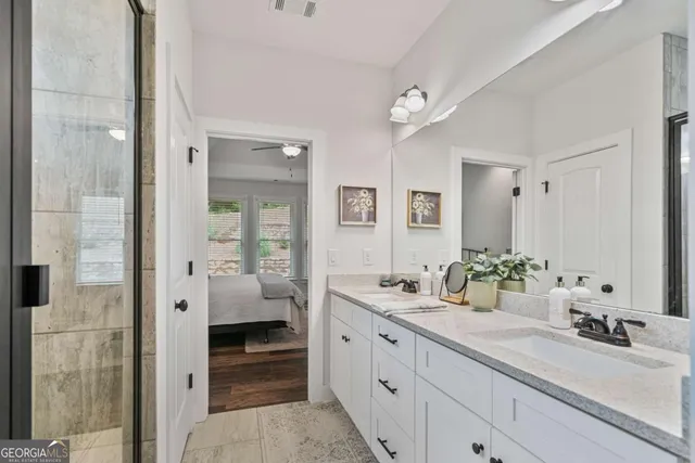 a en suite bathroom with double sink and a large mirror