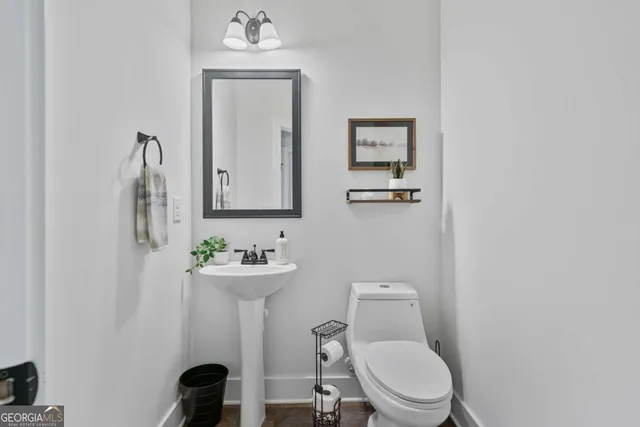 a bathroom with a toilet a sink and mirror