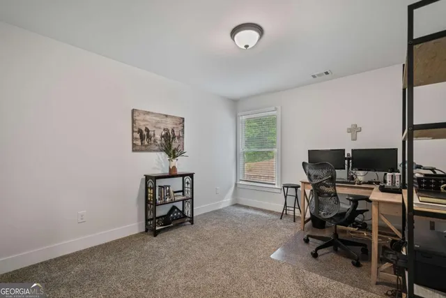 a view of a workspace with furniture and a window