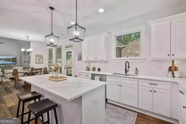 a kitchen that has a lot of cabinets in it and wooden floors