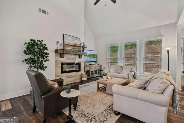 a living room with furniture a large window and a fireplace