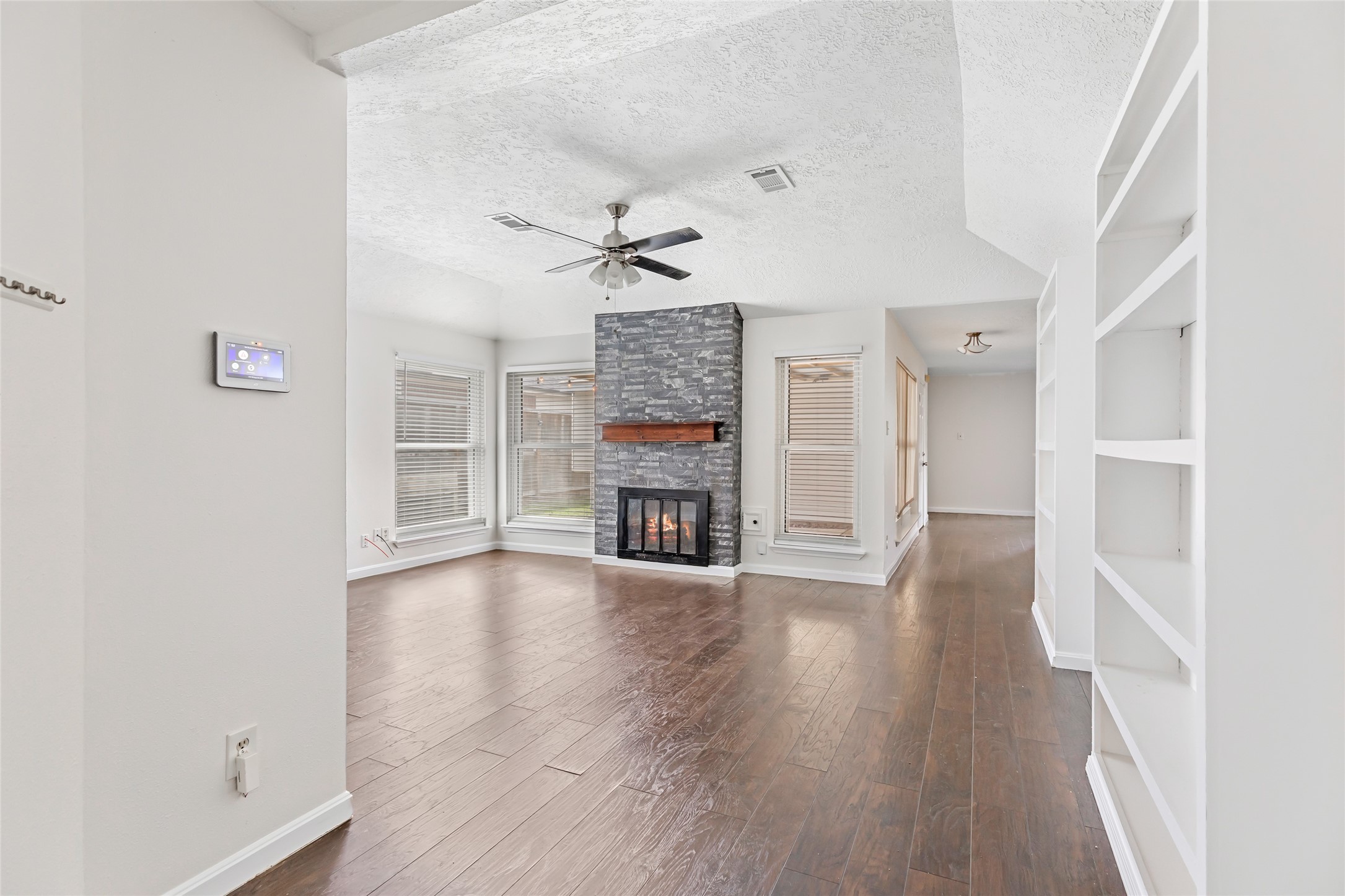 2810 Spring Dusk Drive Spring, TX 77373 - Photo 11 of 30 an empty room with wooden floor fireplace and windows