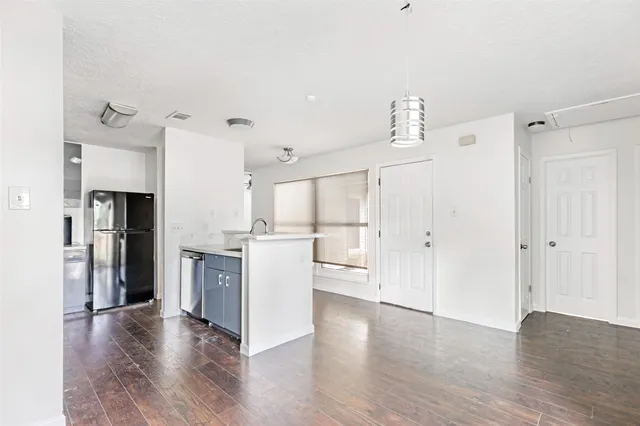 an empty room with cabinet and windows