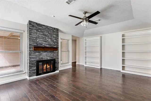 a view of an empty room with a fireplace and a window