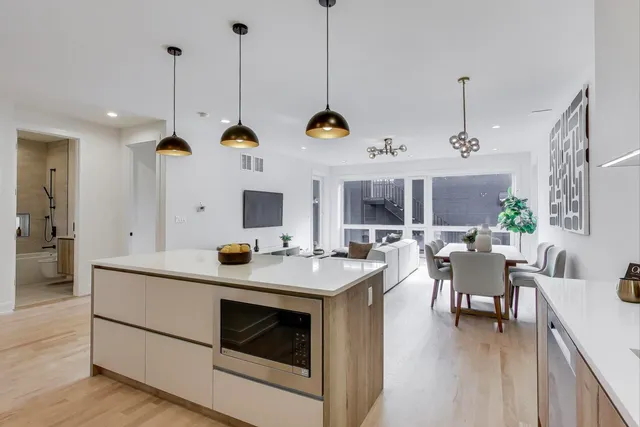 a kitchen with a stove a window and chairs