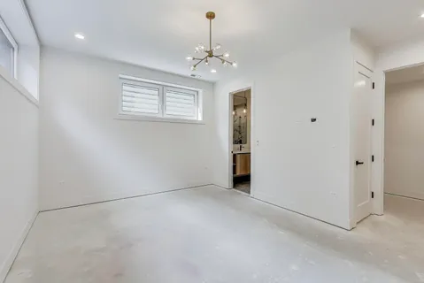 en empty room with windows and chandelier