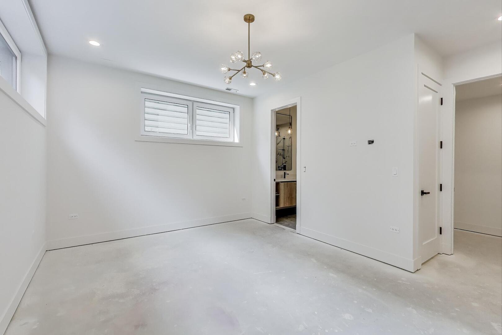 2147 West Adams Street, Unit 1S Chicago, IL 60612 - Photo 17 of 44 en empty room with windows and chandelier