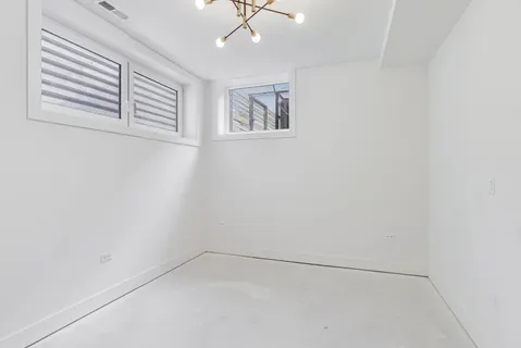 an empty room with windows and ceiling fan