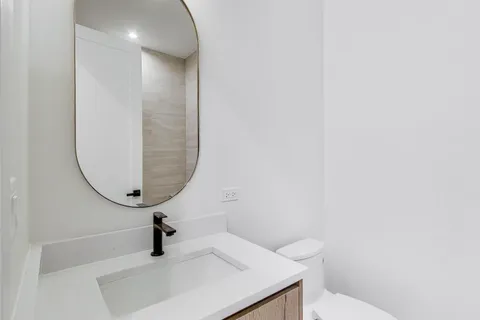a bathroom with a sink a toilet and a mirror
