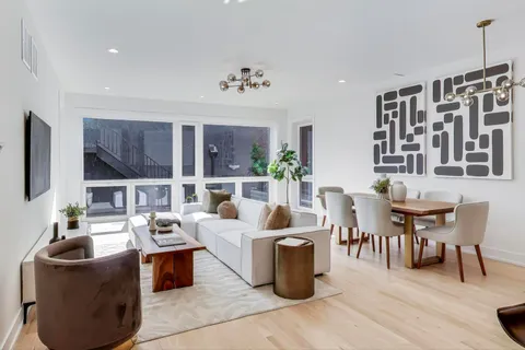 a living room with furniture a flat screen tv and a floor to ceiling window
