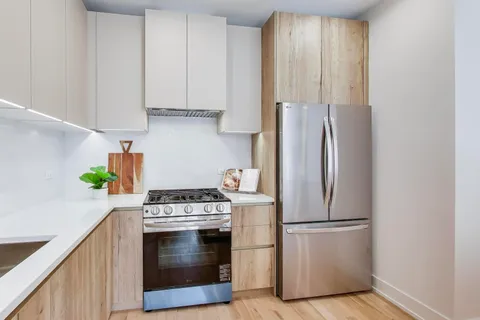 a kitchen with stainless steel appliances granite countertop a refrigerator sink and stove