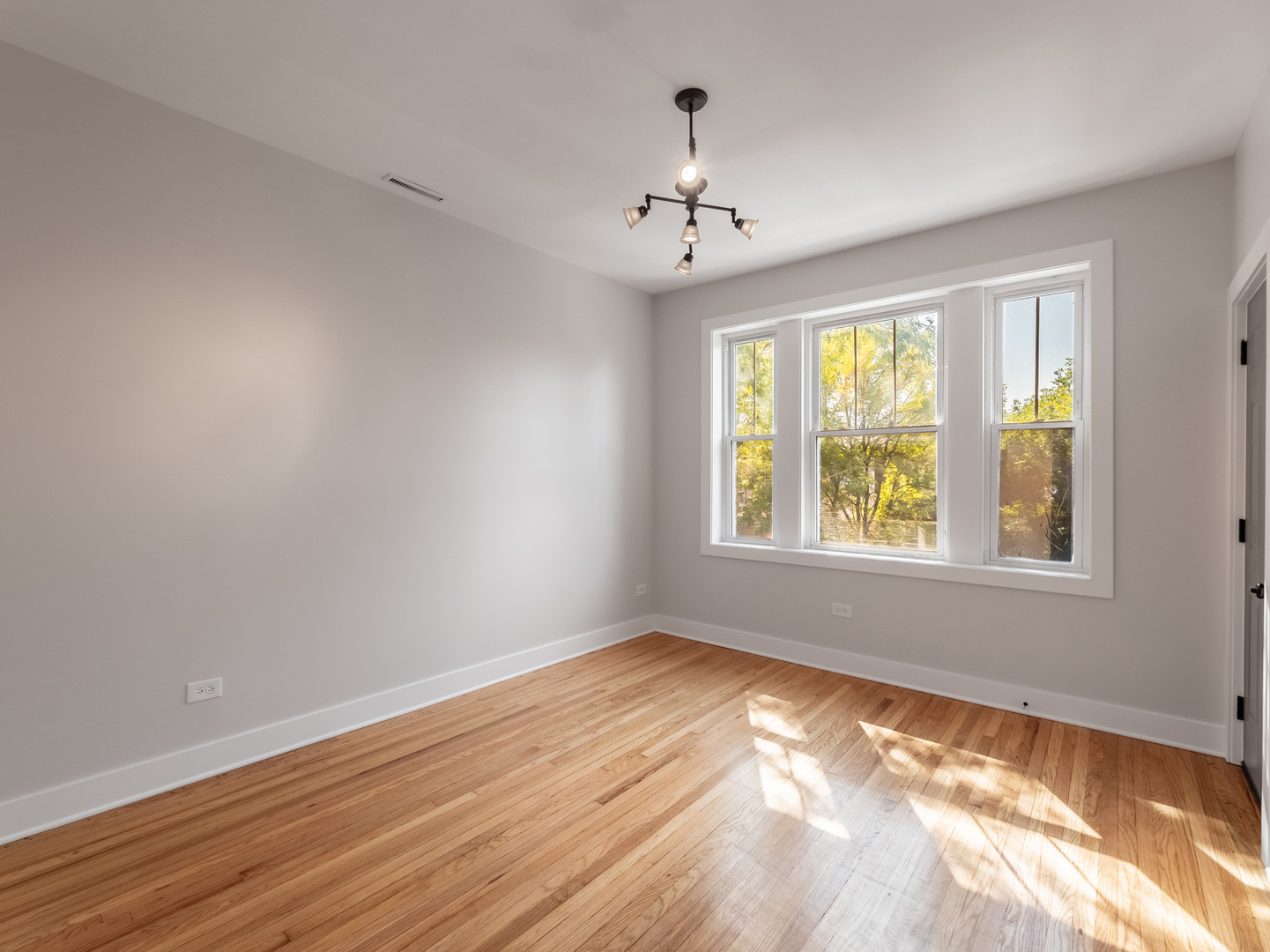 2940 West Pershing Road Chicago, IL 60632 - Photo 2 of 11 a view of an empty room with wooden floor and a window