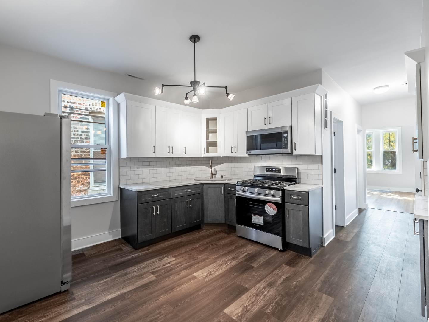 2940 West Pershing Road Chicago, IL 60632 - Photo 4 of 11 a large kitchen with granite countertop a stove top oven a sink dishwasher a dining table and chairs with wooden floor