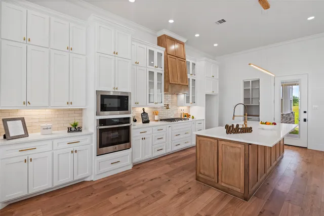 a kitchen with white cabinets and sink