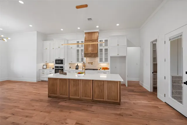 a large kitchen with stainless steel appliances a sink and refrigerator