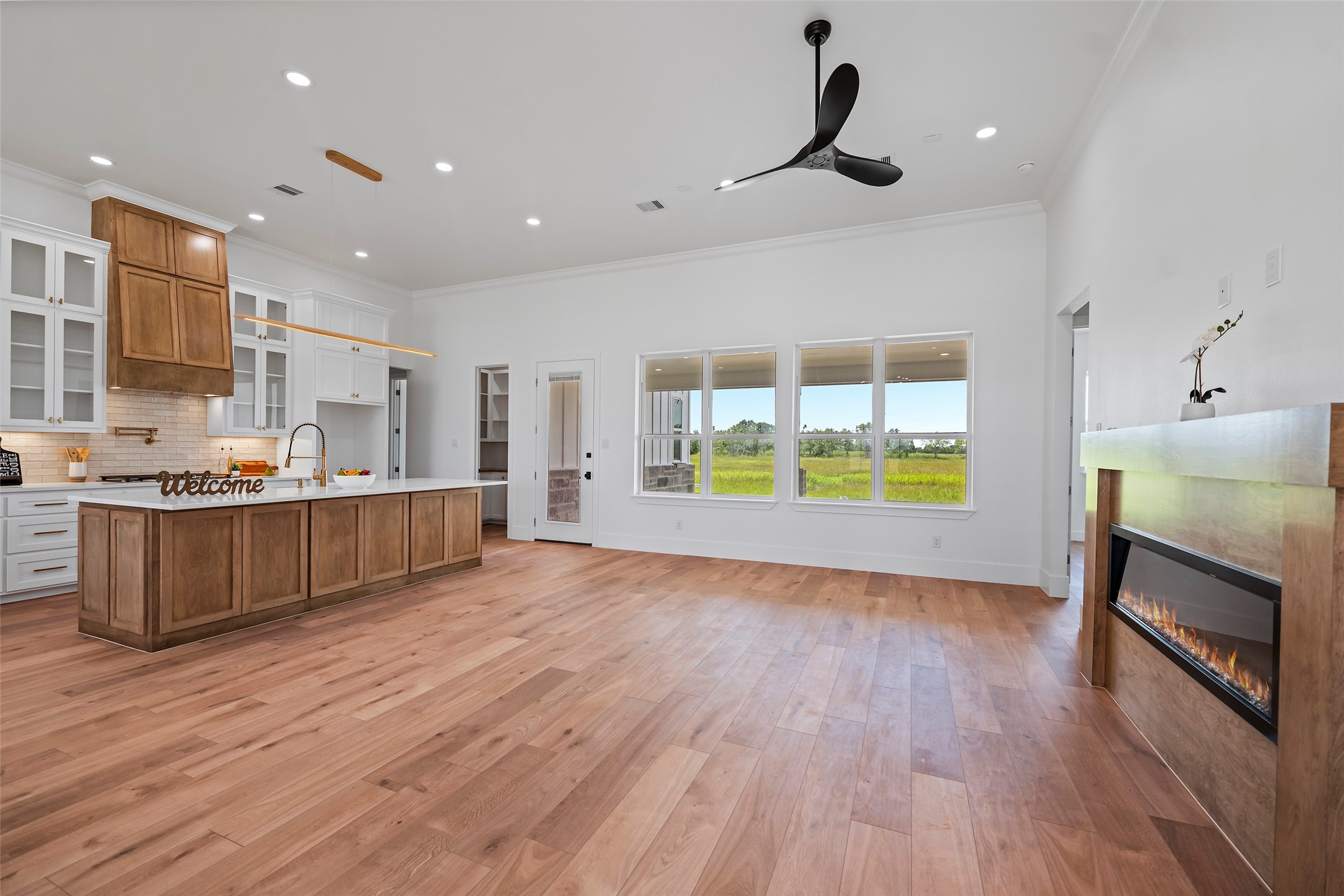 413 Chuckwagon Trail Angleton, TX 77515 - Photo 19 of 46 a view of an empty room and kitchen with wooden floor