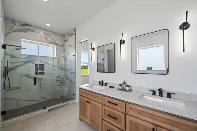 a bathroom with a granite countertop sink mirror and shower