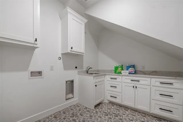 a kitchen with white cabinets and sink