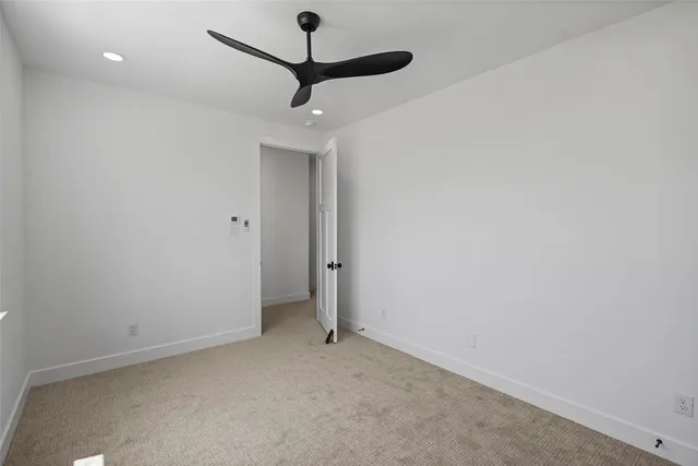 en empty room with a fan and a ceiling fan